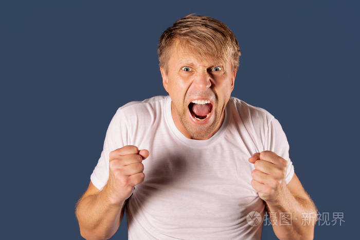 一个愤怒的男人在灰色背景下握着拳头的画像