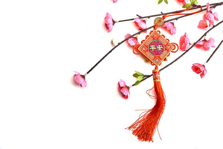 梅花粉樱桃枝，白色背景上有中国幸运结的中国新年装饰品英文翻译为外文，意思是祝福