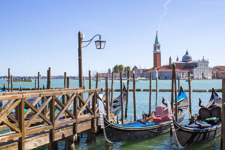 意大利威尼斯蓝天码头上的传统贡多拉斯