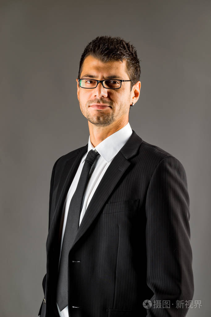 一个穿黑色西装的严肃男人.黑暗的背景.