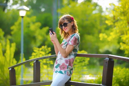 在一个愉快的夏天，开朗的女孩用手机。