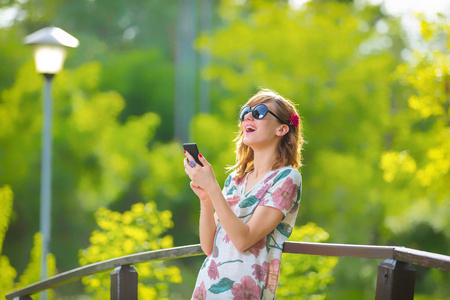 在一个愉快的夏天，开朗的女孩用手机。