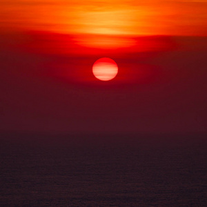 用长焦镜头拍摄的海洋地平线上的日落。