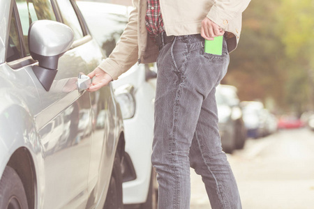 男人走进他的车，在口袋里检查手机。