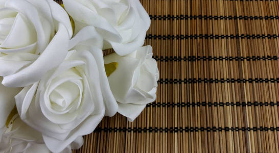 藤背景上装饰的白玫瑰与复制空间