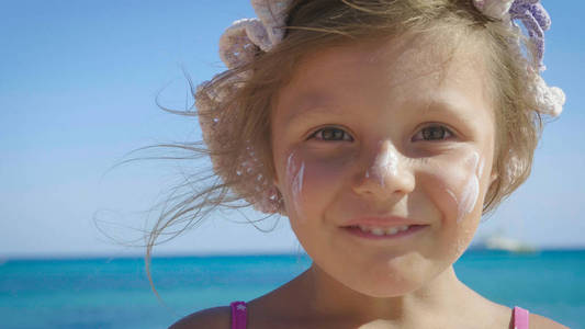 美丽的小女孩在海上玩得开心的肖像，可爱的微笑，在巴拿马的防晒霜背景下，海水碧水。 概念儿童童年夏季自由儿童婴儿夏季。