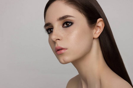 特写美女与干净的光泽皮肤和黑暗的烟雾阴影棕色的眼睛和头发.