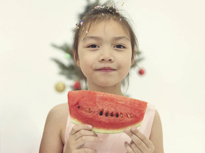 快乐的亚洲孩子吃西瓜。