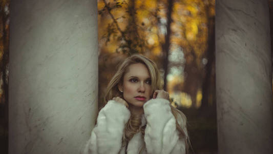 秋天，冬天，美丽的金发女人，穿着一件灰色外套，神情忧郁