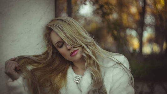 秋天，冬天，美丽的金发女人，穿着一件灰色外套，神情忧郁