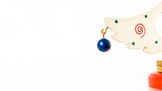 圣诞白票，上面挂着一个蓝色的木球，挂在一棵木制玩具圣诞树的树枝上