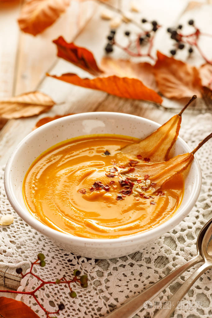 南瓜汤在白色陶瓷碗中加入梨片美味健康的纯素汤