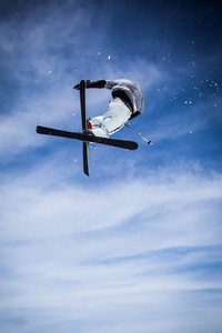 滑雪者在空中跳跃，背景是蓝天。