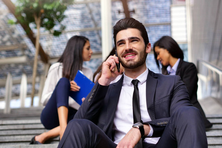 一个穿西装打领带的商人在打电话时很高兴，笑着。 概念技术网络成功。