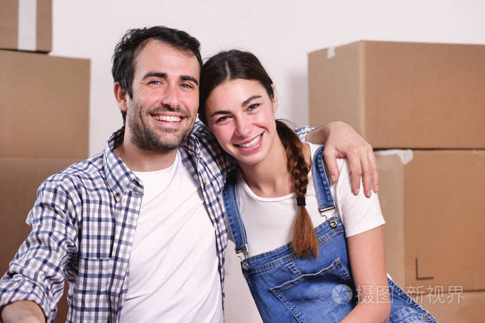 快乐微笑的白种人男女抱着盒子,看着镜头