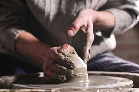 他用粘土和他的手在实验室里创造了一个漂亮的花瓶。 工匠用手创作艺术品。 概念体验艺术传统粘土。