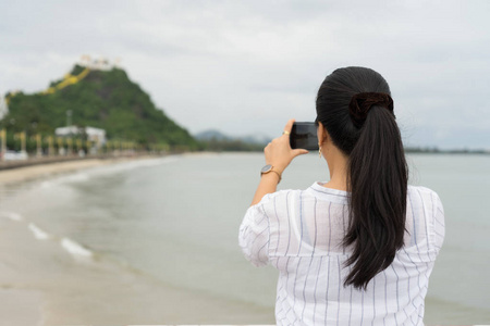 女子站在赤竹泰国塔米坎寺的智能手机上拍照