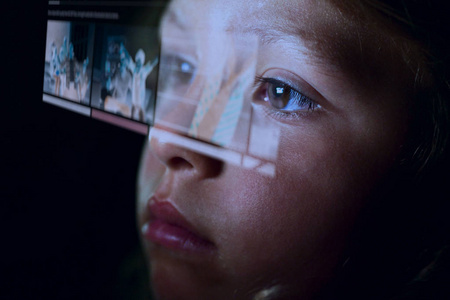 接近一个小女孩孩子看一些未来的全息图。 概念技术未来图形