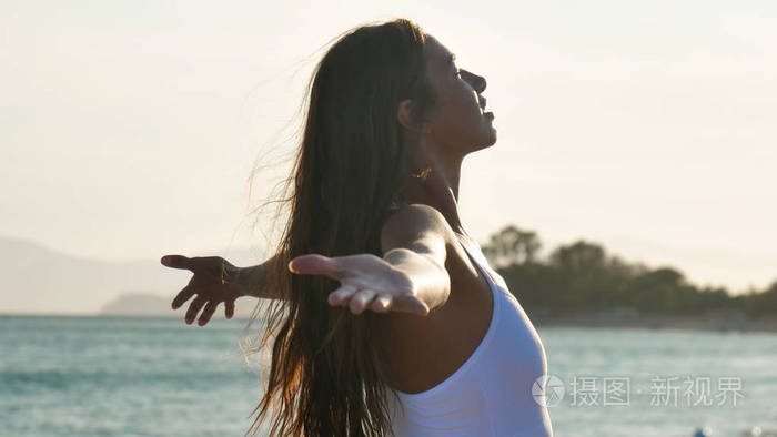 呼吸的女人张开双手站在户外