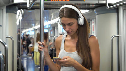 一位美丽的少女女在电话里听音乐的画像，开心的笑着，在地铁里..概念旅游，热爱旅游，交流，自由，热爱生活，生活方式，火车，旅
