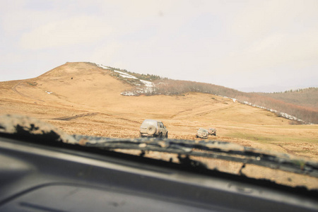 在山上坐车旅行。 在国外。 从窗户看到乌克兰喀尔巴阡山脉和森林。 肮脏的吉普车。