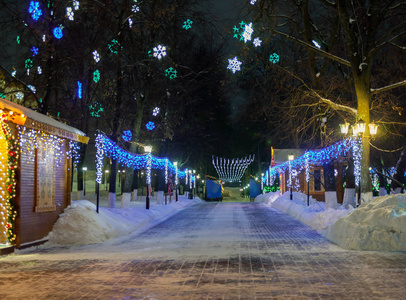 在冬季城市的街道上装饰着燃烧的灯光的圣诞房屋