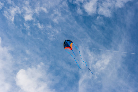 一只风筝在明亮的蓝色多云的天空中翱翔。自由飞行和欢乐的概念