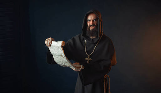 中世纪有一张邪恶的脸的僧侣在古代手稿宗教中读一篇祈祷文.