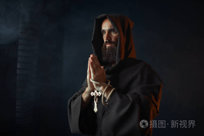 中世纪僧侣穿着黑色长袍戴着头巾闭着眼睛祈祷秘密仪式神秘的修士穿着