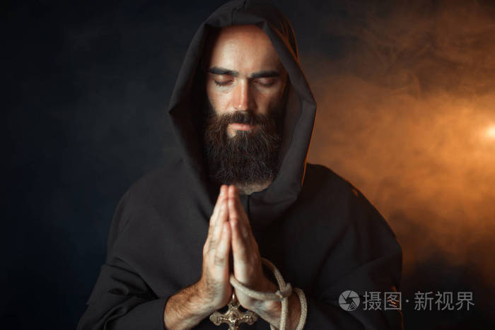 中世纪僧侣穿着黑色长袍戴着头巾闭着眼睛祈祷秘密仪式神秘修士穿着黑