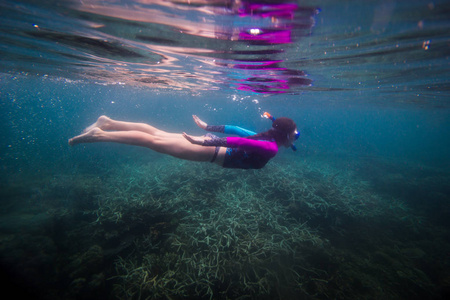 女人在水下游泳美丽的女人在水下潜水之前到珊瑚礁女人浮潜在蓝色面具浮潜在面具热带海洋浮潜暑假活动