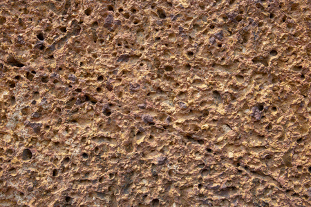 粗糙的沙石纹理.多孔橘石特写.风化粗糙的表面照片背景.