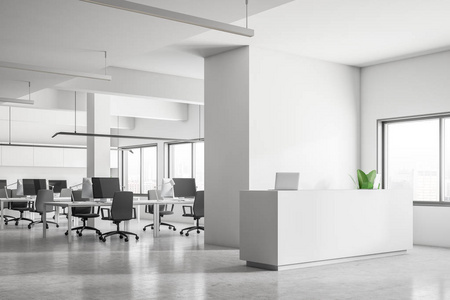 开放式办公室的内部,有一排电脑办公桌,白色墙壁和混凝土地板.