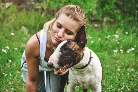 在绿草与斗牛犬的女孩