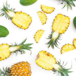 白色背景下由菠萝和芒果水果制成的热带食物图案。 平躺式顶部视图
