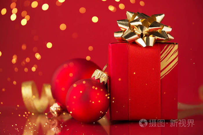 带金色丝带的红色礼品盒和红色背景上的圣诞包