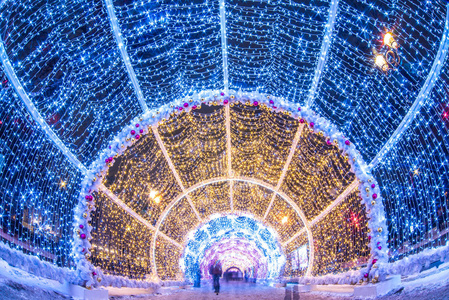 在莫斯科市中心，人们穿过新年和圣诞节的灯光隧道