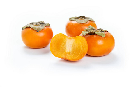 白色背景上的橙色柿子，特写。