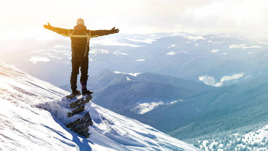在阳光明媚的冬日,举起双手欣赏风景和成就