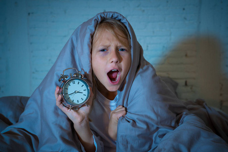 可爱的不眠之夜的小女孩在床上醒着, 在半夜看起来很累, 晚上不睡觉