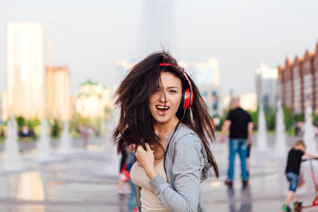 女孩用耳机听音乐，在街上跳舞。