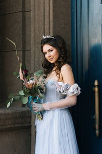 高加索快乐浪漫的新娘带着一束不寻常的花束漫步在欧洲城市。 婚礼的概念。