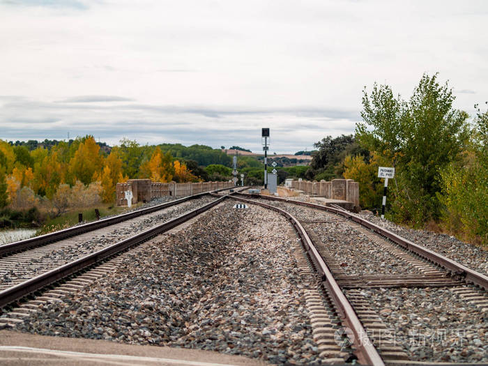 在火车轨道上的十字路口穿过秋天的风景天空中有云