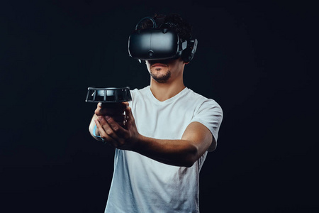 身穿白衬衫的男子穿着虚拟现实护目镜玩游戏