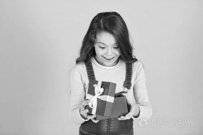 小女孩惊喜的礼物.女孩卷曲的发型可爱的疑惑的脸庆祝生日.