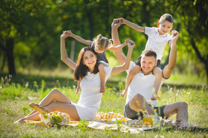 快乐的家庭野餐父母和他们的孩子在户外吃晚饭