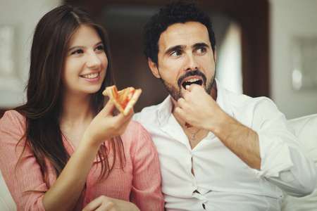 夫妻俩吃披萨看电视
