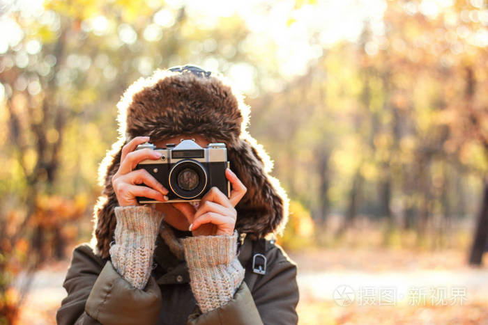 年轻女子在秋天公园拍照概念女摄影师