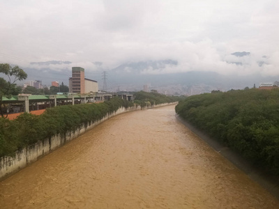 阴天时流经一个城市的一条浑浊的褐色河流