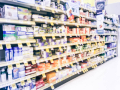 复古色调模糊了抽象的广泛选择维生素和补充剂在货架上显示与折扣价格标签在德克萨斯州美国杂货店。